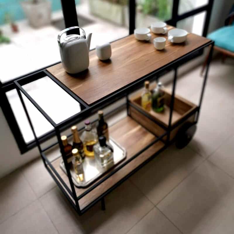 Carro de bar con estantería de madera y metal para bebidas y utensilios.