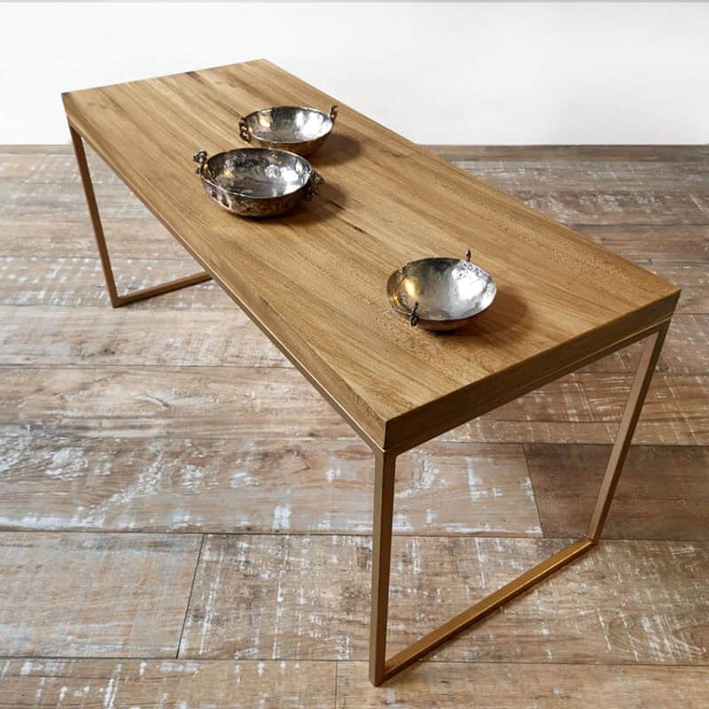 Mesa minimalista de madera con estructura dorada en Tienda Quadrat.
