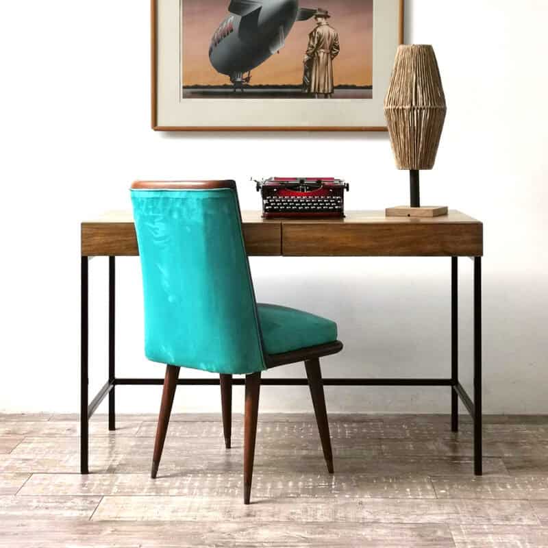 Escritorio de madera con silla azul y decoración moderna.
