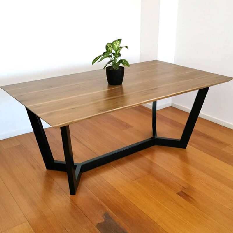 Mesa moderna de madera y estructura negra en ambiente minimalista.