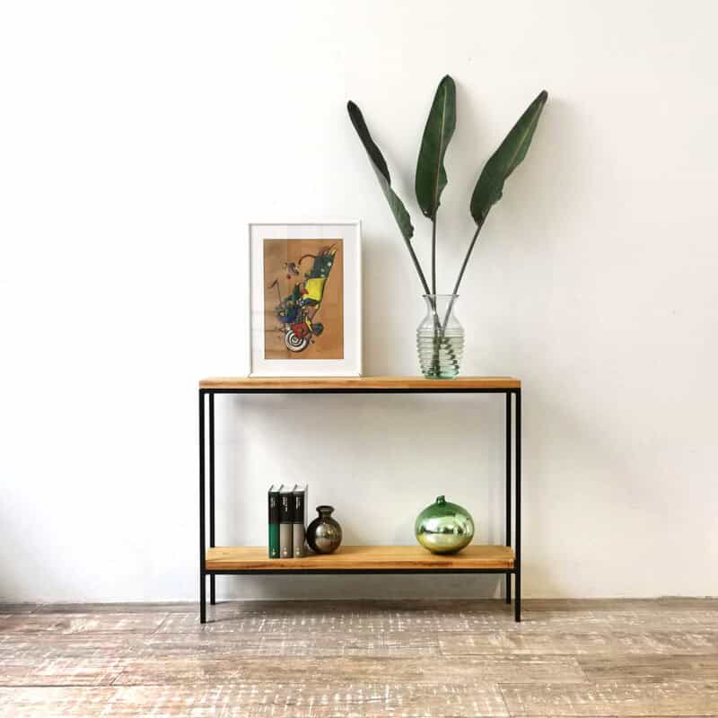 Mueble consola minimalista con plantas y decoración moderna en interior.