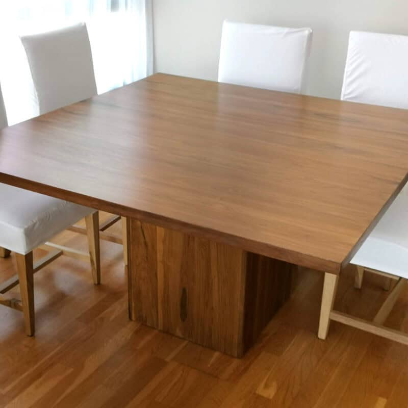 Mesa Holanda de madera con sillas blancas en comedor moderno.