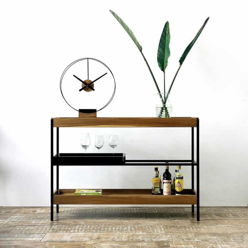 Mueble minimalista con reloj y plantas en Tienda Quadrat.