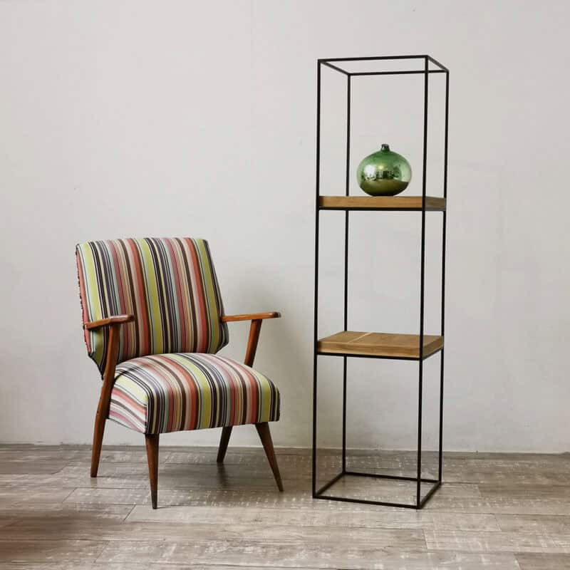Silla vintage con rayas y estantería de metal y madera en fondo blanco.