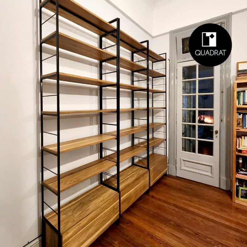 Estantería de pared con estructura metálica y estantes de madera en ambiente interior.
