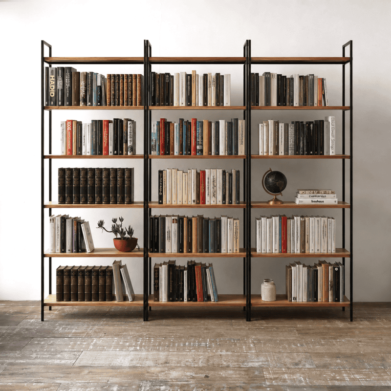 Estantería de pared con libros y accesorios decorativos en ambiente minimalista.